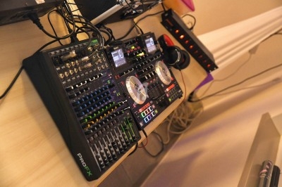Table de mixage professionnelle avec platines, curseurs, boutons et casque audio posés sur un bureau.