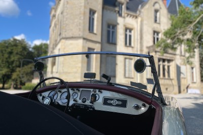 Miniature Location salle Castres (Tarn) - Château du Causse #19 Voiture ancienne jaune et noire stationnée devant un bâtiment historique en pierre, sous un ciel partiellement dégagé.