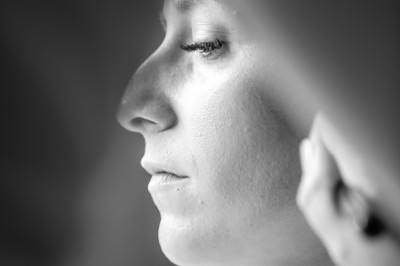 Miniature Benjamin Dessolle Photographe #44 Femme de profil se faisant maquiller les lèvres avec un pinceau dans un cadre lumineux.