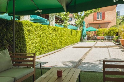 Miniature Location salle Saint-Cyr-au-Mont-d'Or (Rhône) - Le Comptoir de Saint Cyr #9 Terrasse extérieure avec tables en bois, chaises et parasols verts, entourée de haies et d'arbres.