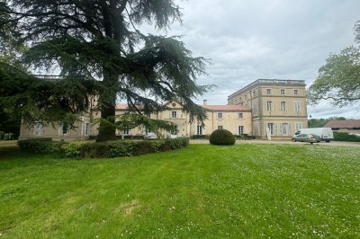 Miniature Location salle Saint-Nicolas-de-la-Balerme (Lot-et-Garonne) - Chateau Saint Philip #6 Un couple en tenue de mariage marche dans une salle en briques, avec un bouquet de fleurs au premier plan.