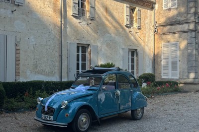 Miniature devant le château Un couple en tenue de mariage marche dans une salle en briques, avec un bouquet de fleurs au premier plan.