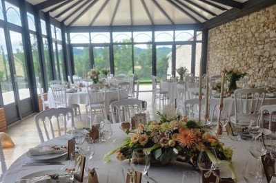 Miniature la véranda de la salle de réception Un couple en tenue de mariage marche dans une salle en briques, avec un bouquet de fleurs au premier plan.