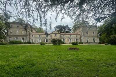 Miniature le château Un couple en tenue de mariage marche dans une salle en briques, avec un bouquet de fleurs au premier plan.