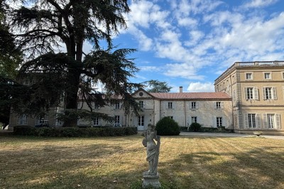 Miniature le château Un couple en tenue de mariage marche dans une salle en briques, avec un bouquet de fleurs au premier plan.