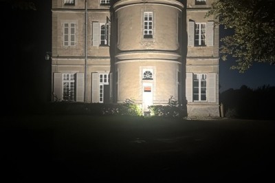 Miniature le château vu de la salle Un couple en tenue de mariage marche dans une salle en briques, avec un bouquet de fleurs au premier plan.