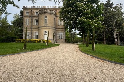 Miniature le château vu de la salle Un couple en tenue de mariage marche dans une salle en briques, avec un bouquet de fleurs au premier plan.