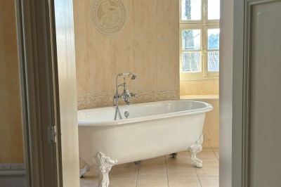 Miniature salle de bain d'une suite Un couple en tenue de mariage marche dans une salle en briques, avec un bouquet de fleurs au premier plan.