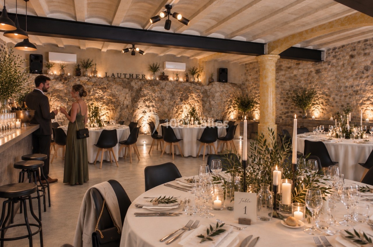 Salle de réception élégante avec tables décorées, bougies et végétation, deux personnes discutant au fond.