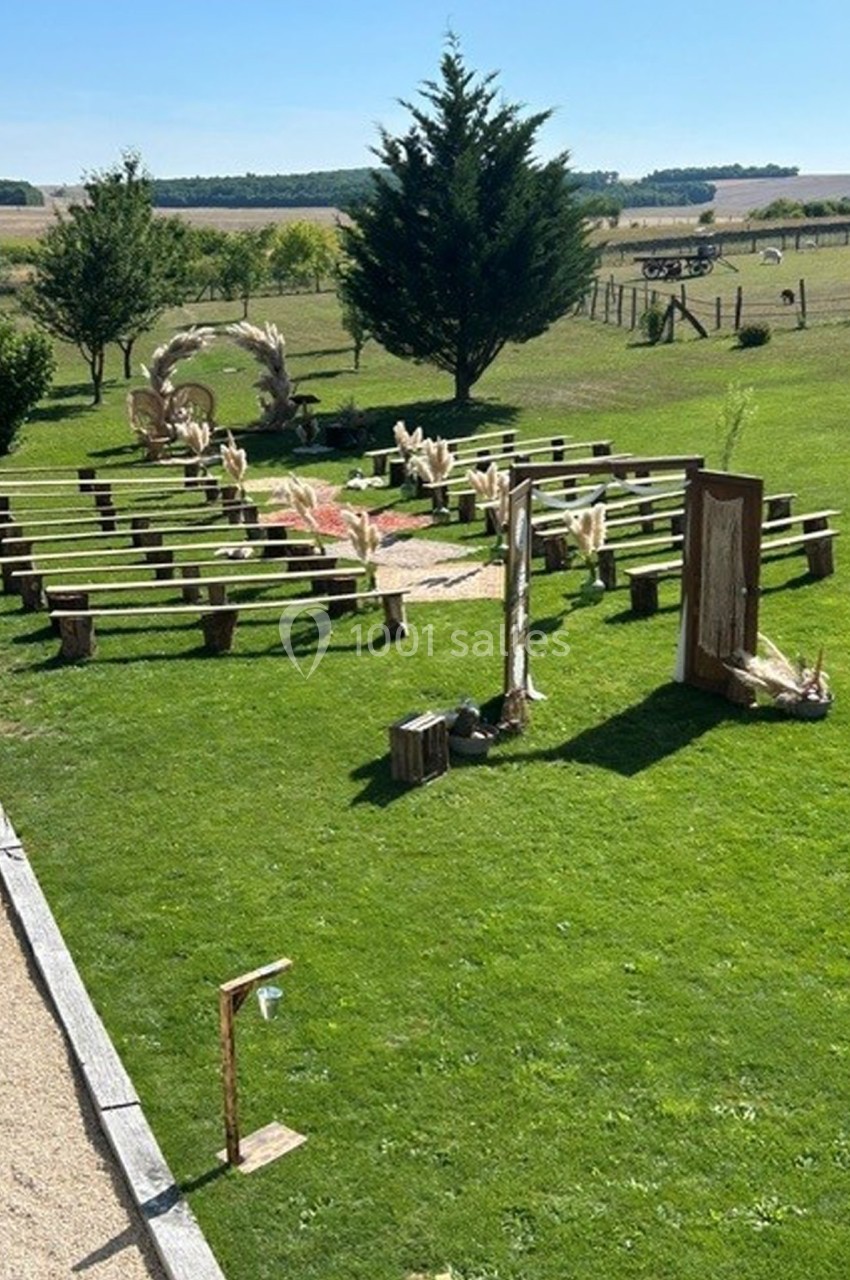 Disposition de chaises en cercle sur une pelouse, décorée pour une cérémonie en plein air avec des arches et des éléments…