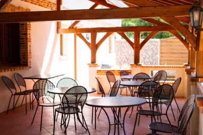 Serviette blanche pliée avec un menu enroulé et une branche d'eucalyptus, posée sur une assiette blanche.
