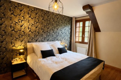Salle de réunion spacieuse avec une grande table en bois, chaises en cuir, écran et décoration moderne.