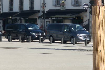 Miniature Vtc Hrc #3 Deux véhicules Mercedes noirs stationnés sur un sol pavé devant un bâtiment en pierre sous un ciel nuageux.