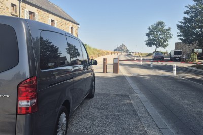 Miniature Vtc Hrc #4 Minibus noir stationné devant l'entrée de l'aéroport de Vannes avec une tour de contrôle en arrière-plan.