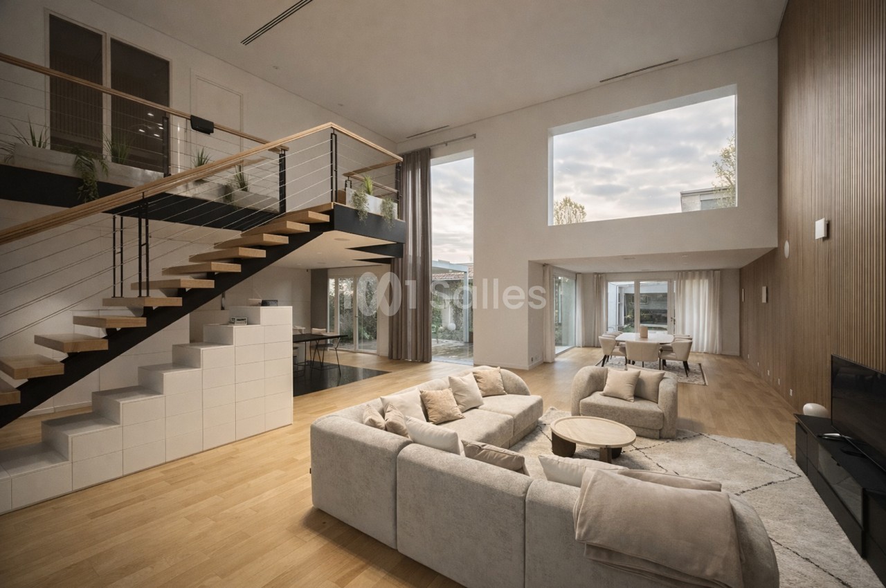 Intérieur contemporain spacieux avec salon agencement ouvert, escalier bois, cuisine îlot, baies vitrées, mobilier épuré beige.