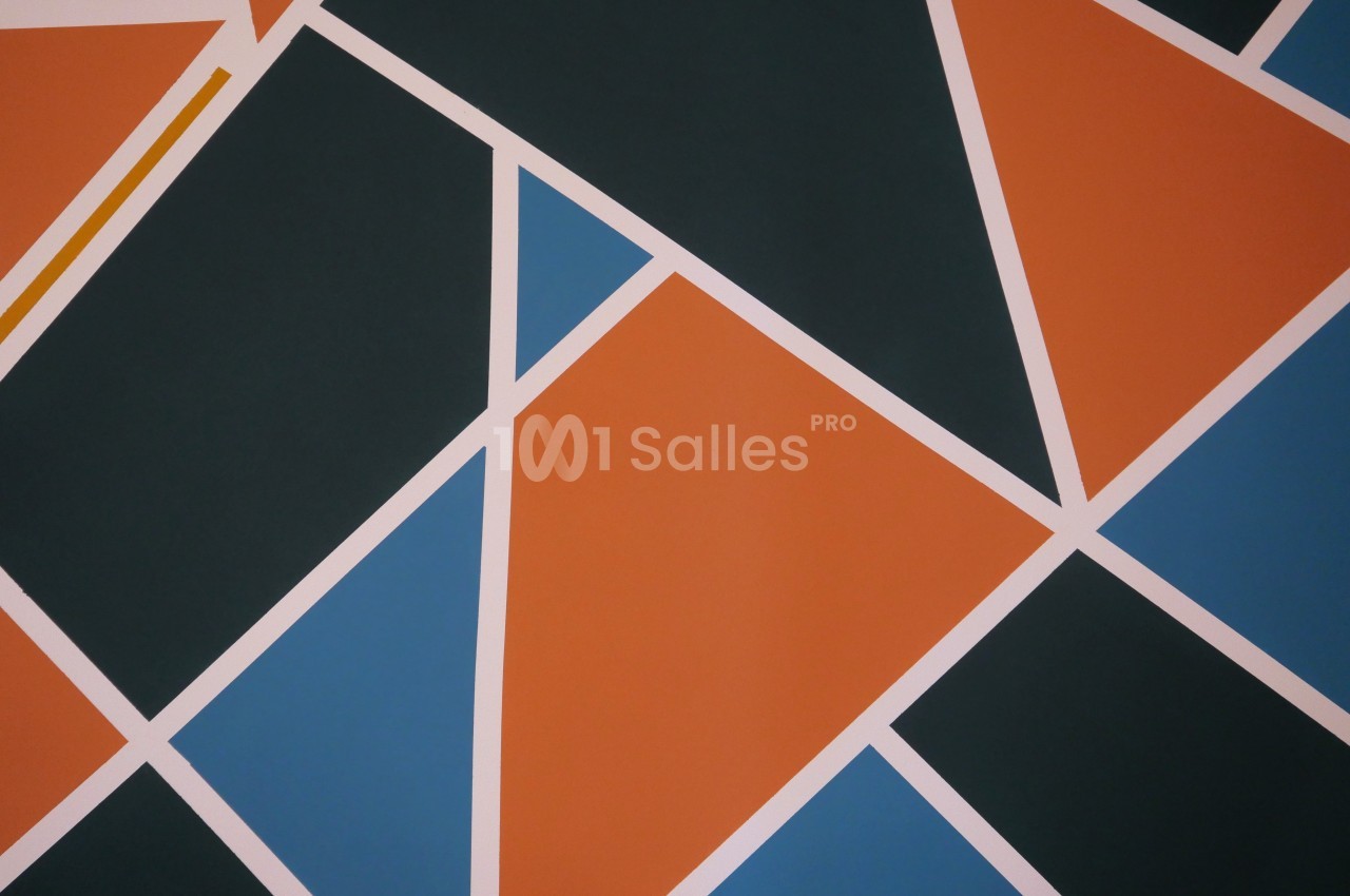 Composition géométrique abstraite aux formes triangulaires oranges, bleues et noires séparées par des bandes blanches.