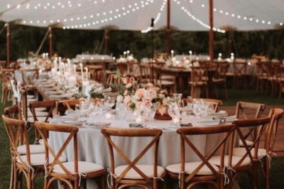 Miniature Comtralala #7 Tables décorées pour un dîner en plein air sous une tente éclairée de guirlandes lumineuses, près d'un bâtiment en pierre.