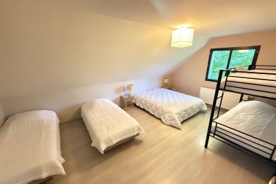 Intérieur d'une tente événementielle avec sol rose, tables blanches et vue sur un espace extérieur verdoyant.