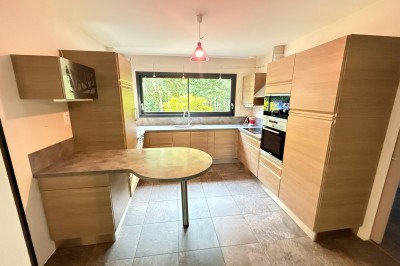 Intérieur d'une tente événementielle avec sol rose, tables blanches et vue sur un espace extérieur verdoyant.