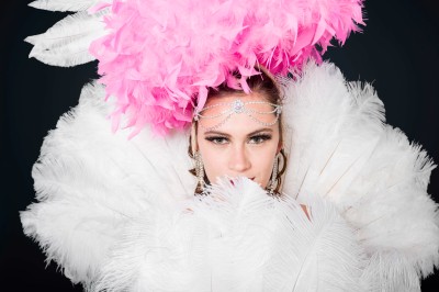 Miniature Cabaret Pierre de Lune #4 Femme debout sur une scène, vêtue de noir, tenant un saxophone doré, éclairée par des projecteurs.