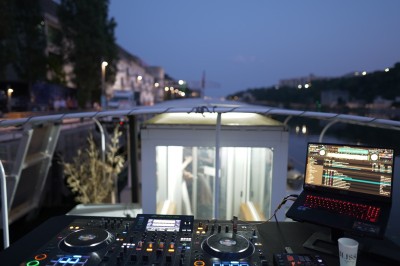 Mains ajustant les commandes d'une table de mixage audio dans un environnement sombre.