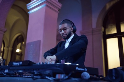 Mains ajustant les commandes d'une table de mixage audio dans un environnement sombre.