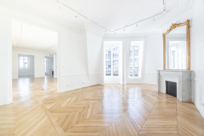 Miniature Location salle Paris 8 (Paris) - Les Appartements By la Fabrique #8 Intérieur lumineux avec parquet en chevrons, cheminée en marbre, miroir doré et grandes fenêtres donnant sur l'extérieur.