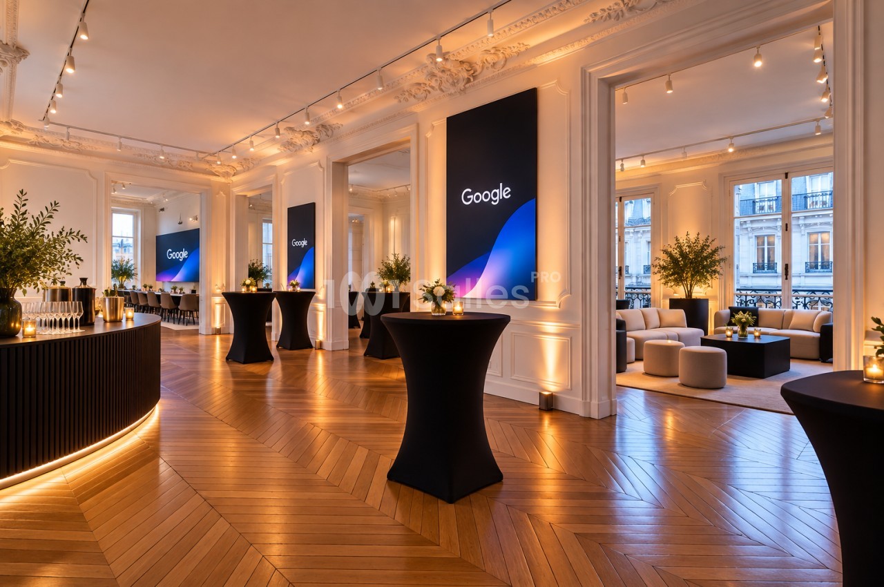 Salle haussmannienne au parquet en chevrons, tables hautes nappées de noir, bar à gauche et salon lounge à droite.
