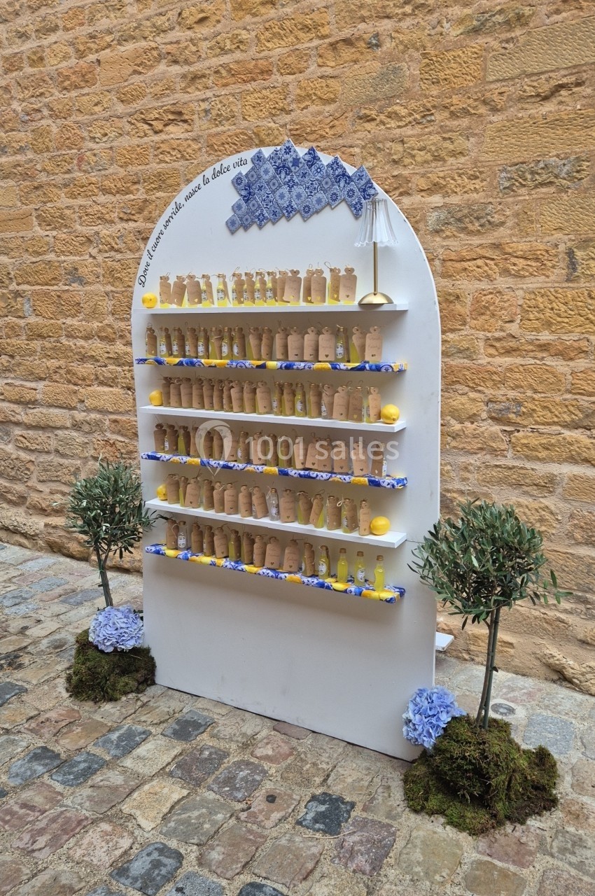 Présentoir en extérieur avec des pots en terre cuite alignés sur des étagères, décoré de fleurs et de motifs bleus.