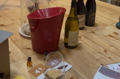 1. Dégustation de vin avec des verres et une roue des arômes sur une table en bois. 2. Verre de vin blanc tenu devant des…