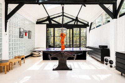 Espace de détente avec bancs et tables en bois, décor alpin avec montagnes en arrière-plan et éclairage chaleureux.