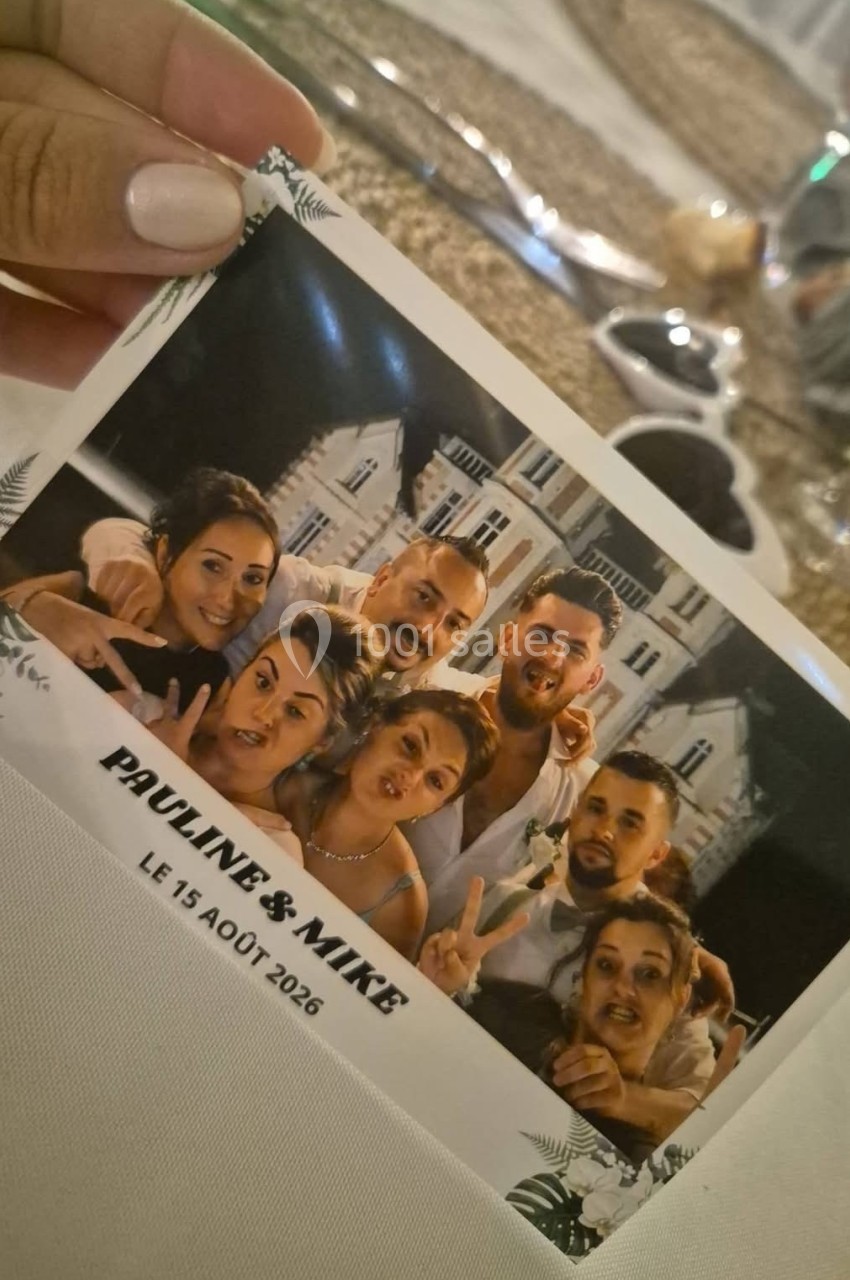 Photo de groupe informelle avec six personnes souriantes posant devant un bâtiment, tenue dans une main.