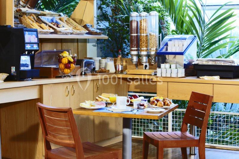 Buffet de petit-déjeuner avec viennoiseries, céréales, fruits et boissons, table dressée pour deux personnes.