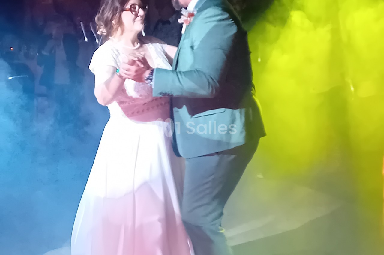 Couple dansant sous éclairage bleu et vert lors d'une animation musicale.