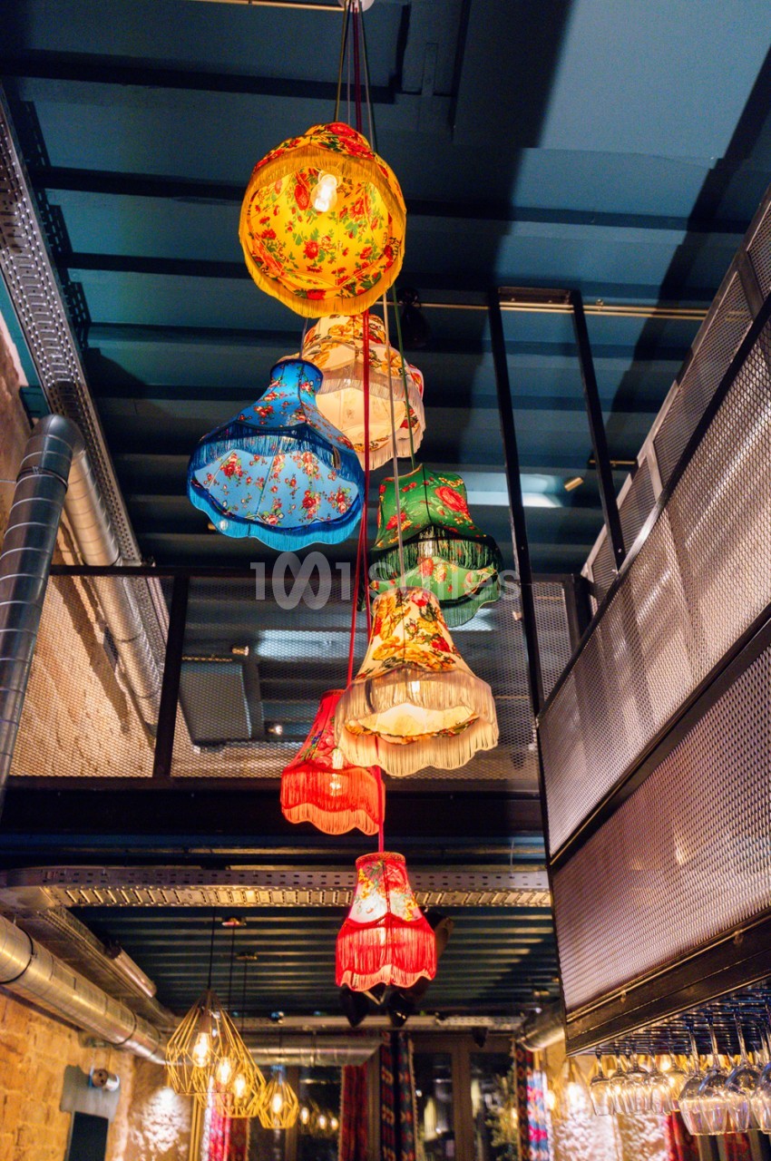 Lanterne asiatique multicolore suspendue au plafond d'un passage intérieur.
