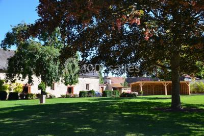 Salle de réception décorée avec des tables dressées, des guirlandes lumineuses et des voilages suspendus au plafond.