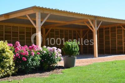 Salle de réception décorée avec des tables dressées, des guirlandes lumineuses et des voilages suspendus au plafond.