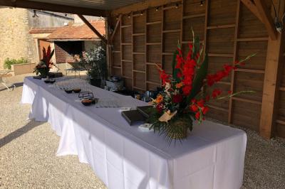 Salle de réception décorée avec des tables dressées, des guirlandes lumineuses et des voilages suspendus au plafond.
