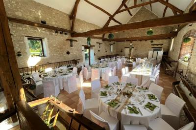 Salle de réception décorée avec des tables dressées, des guirlandes lumineuses et des voilages suspendus au plafond.