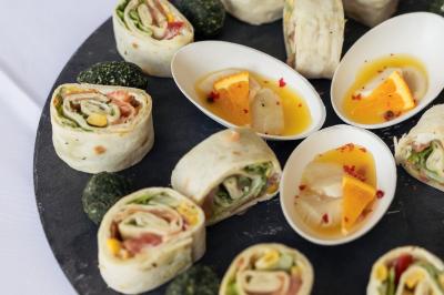 Salle de réception décorée avec des tables dressées, des guirlandes lumineuses et des voilages suspendus au plafond.