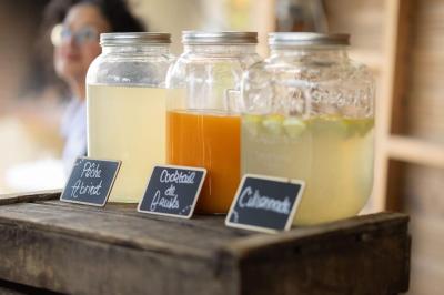 Salle de réception décorée avec des tables dressées, des guirlandes lumineuses et des voilages suspendus au plafond.