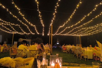 Table en bois à l'extérieur avec des plantes en pot, une boîte aux lettres verte, des paniers et un photomaton en arrière…