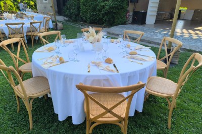 Table en bois à l'extérieur avec des plantes en pot, une boîte aux lettres verte, des paniers et un photomaton en arrière…