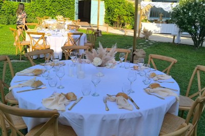 Table en bois à l'extérieur avec des plantes en pot, une boîte aux lettres verte, des paniers et un photomaton en arrière…