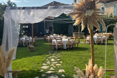 Table en bois à l'extérieur avec des plantes en pot, une boîte aux lettres verte, des paniers et un photomaton en arrière…