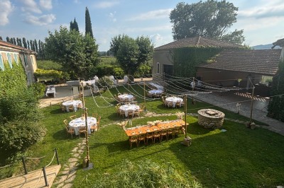 Table en bois à l'extérieur avec des plantes en pot, une boîte aux lettres verte, des paniers et un photomaton en arrière…