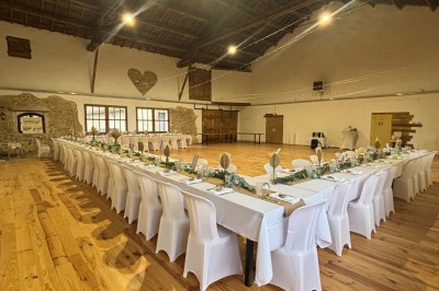 Coccinelle blanche décorée de fleurs blanches pour un mariage, stationnée sous un arbre dans un cadre verdoyant.