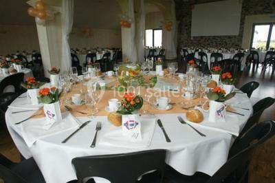 Terrasse en bois avec garde-corps métallique, offrant une vue dégagée sur un paysage champêtre sous un ciel bleu.
