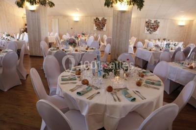 Terrasse en bois avec garde-corps métallique, offrant une vue dégagée sur un paysage champêtre sous un ciel bleu.