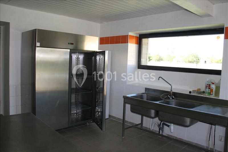 Cuisine professionnelle avec un réfrigérateur en acier inoxydable ouvert, un évier double et une fenêtre donnant sur l…